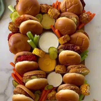 Mini hamburguesas y brochetas en una tabla